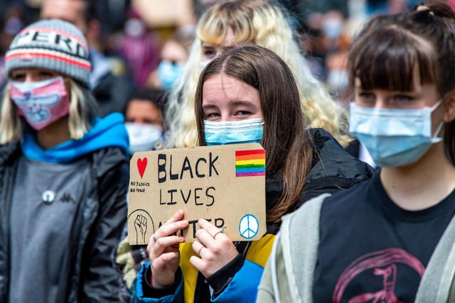 A placard reading 'Black Lives Matter' and 'No Justice, No Peace'