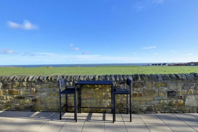 The rear garden has a high level stone wall with views across fields towards the sea