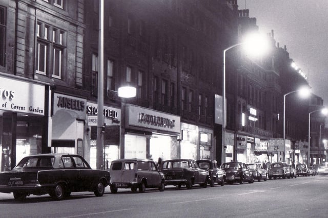 A night time view of some of the shops on Pinstone Street in July 1965