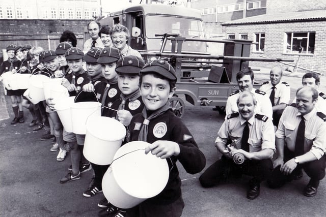 Cub Scouts at Division Street Fire Station poised with buckets in front of the old fire pump with one of the fire crews from Division Street, June 1986