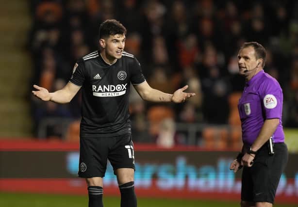 John Egan of Sheffield United questions the offside goal decision with referee Geoff Eltringham against Blackpool: Andrew Yates / Sportimage
