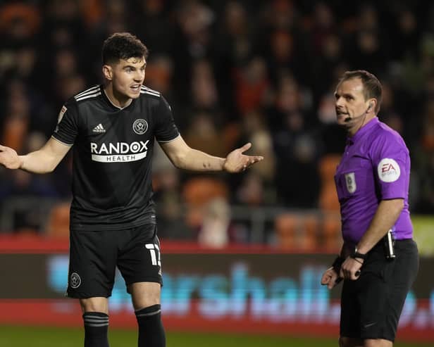 John Egan of Sheffield United questions the offside goal decision with referee Geoff Eltringham against Blackpool: Andrew Yates / Sportimage