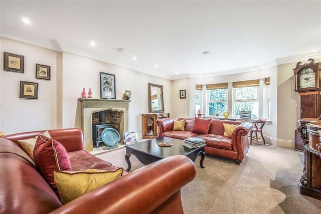 There are six reception rooms in total, including this generously sized living room with a large fireplace and plenty of room for seating.