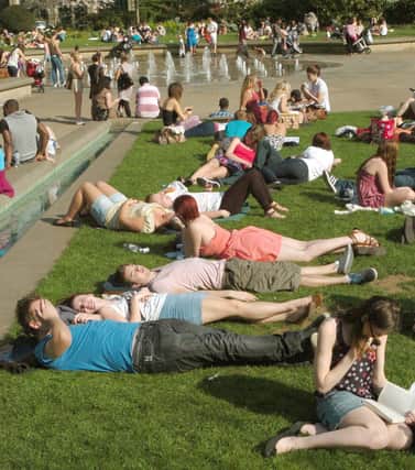 Sheffield people sunbathing and relaxing in the sunshine at the Peace Gardens.