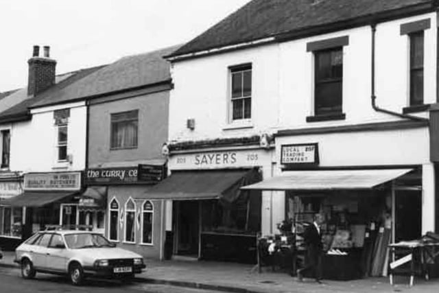 Shops on London Road, Sheffield, in September 1987, showing (right to left) Local Trading Company, upholsterers sundries (No.207); Sayer's (No.205); the Curry Centre (No.203); Yun Stores Ltd, butchers (No.201) and T. and B. Arnold, bakers and confectioners (No. 199)