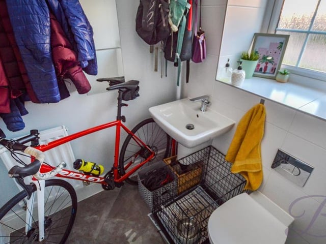 Doubling up as a cloakroom at the moment (and indeed a bike garage!) is the downstairs toilet. Complete with full-height tiling, it has a wall-hung wash basin, a low-flush WC, central-heating radiator and opaque window.