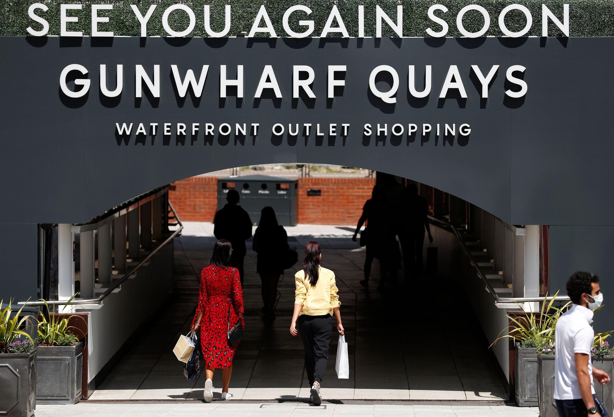 Shoppers carry bags as they leave after visiting recently re-opened shops at Gunwharf Keys shopping centre in Portsmouth as some non-essential retailers begin to reopen.