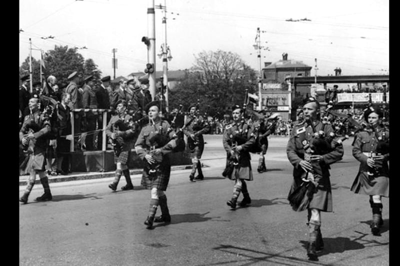 Bagpipes through Guildhall Square Wings for Victory week
On May 28, 1943, the Secretary of State for Foreign Affairs Rt. Hon. Anthony Eden K.C. MP visited the city.
It was Wings for Victory week and a large parade of servicemen and women  plus the  police paraded through the square.
Eden can be seen on the platform at the rear, in the suit.