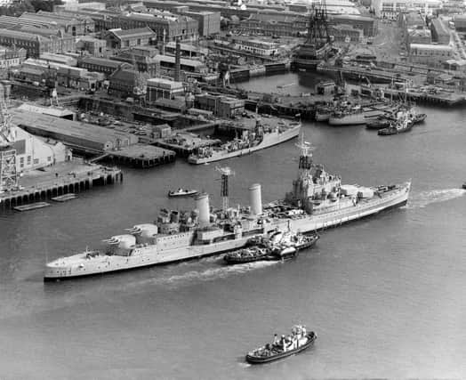 The Royal Navy Town-class light cruiser HMS Belfast under tow from tugboats passes the18th century 104-gun first-rate ship of the line and Admiral Lord Nelson's flagship HMS Victory on her last voyage from Portsmouth Dockyard to her new berth in London as a floating museum on 2 September 1971 in Portsmouth, United Kingdom.  (Photo by Keystone/Hulton Archive/Getty Images).
