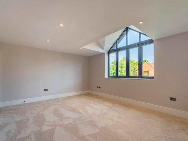 A window full of character adds to the charm of this bedroom. It sits above the integral double garage, which has automated doors.