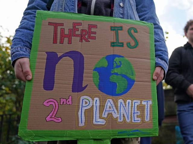 Demonstrators at Kelvingrove Park, with a placard reading: "There is no second planet"