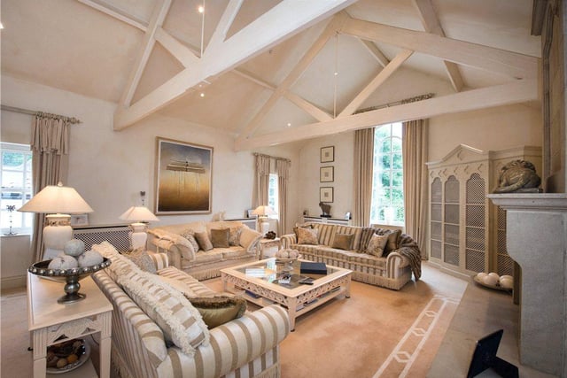 The stylish living room provides plenty of space for both family and entertaining guests, with a large fireplace at its heart and characterful wooden beams overhead.