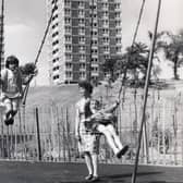 Children in a playground at Herdings, Sheffield, in 1969, with tower blocks in the background.