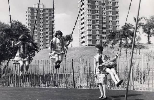Children in a playground at Herdings, Sheffield, in 1969, with tower blocks in the background.