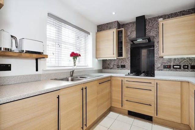 The front-facing kitchen is kitted with modern appliances and a gas hob.