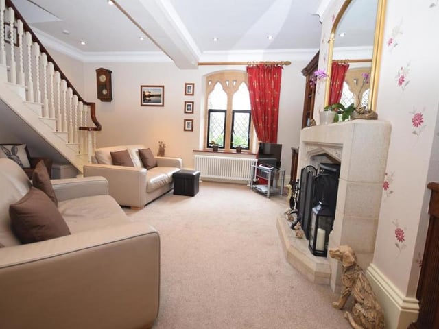 The other main space on the first floor is this striking living room, which has a sophisticated feel to it. The stone feature fireplace, with its log-burning stove, creates a warm and homely ambience. The beautiful, showstopping double stone window offers glorious views of Newstead Abbey and its upper lake.