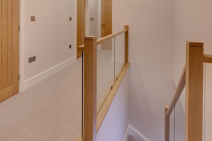 A staircase with an oak hand rail, glazed balustrading and feature lighting rises to the first-floor landing, which has front and rear-facing obscured glazed panels, recessed lighting, pendant light point and under-floor heating.