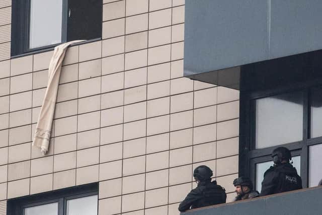 Armed police stood on the balcony of The Gateway apartment block looking up to the flat where Yaqub Younis claimed he had 20kg of explosives. Younis claimed all of the officers outside his flat were “assassins from MI5.”