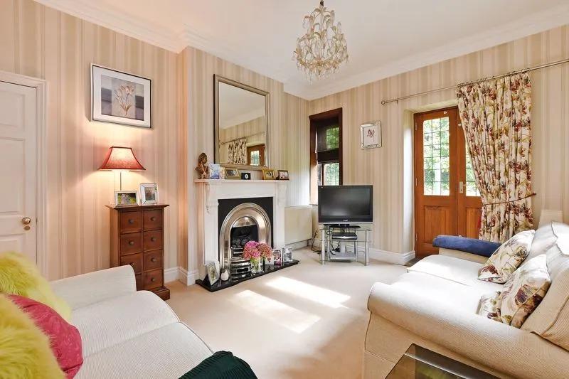The lounge is a charming room with a high ceiling, character windows with stone mullions, a focal coal gas fire and surround, a cute recess with a fitted cabinet and shelving above.