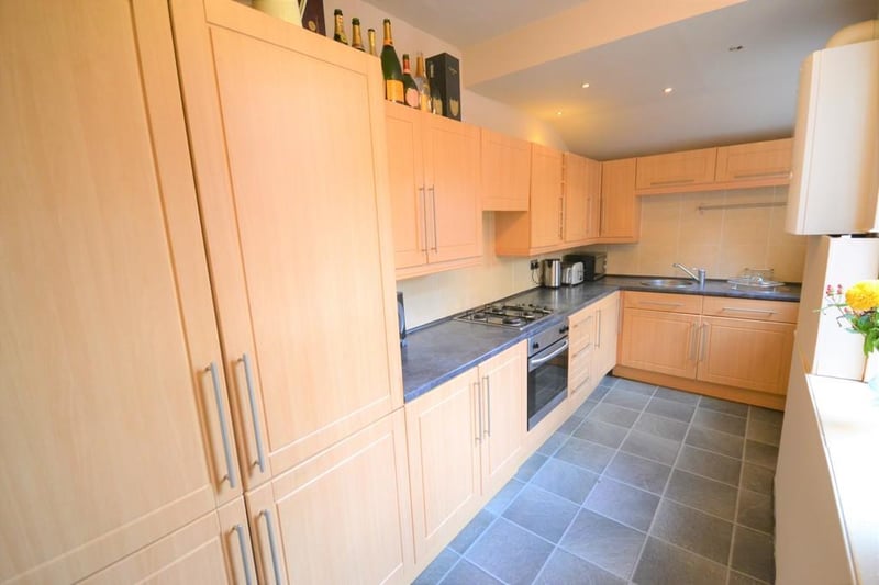 Wellpresented kitchen having an excellent range of oak effect wall and base units with contrasting roll top work surfaces and splashback wall tiles. Integrated oven,  with extractor fan, built in fridge freezer.  A stable type wooden door opens to the rear garden.