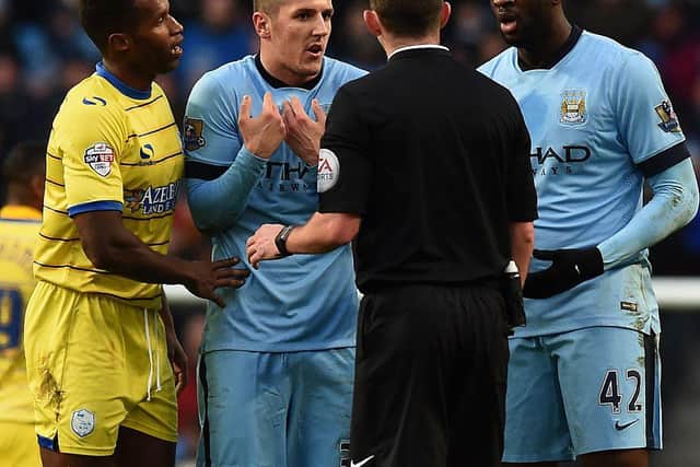 Sheffield Wednesday's Portuguese midfielder Jose Semedo (L), Manchester City's Montenegrin striker Stevan Jovetic (2nd L) and Manchester City's Ivorian midfielder Yaya Toure (R) speak to referee Michael Oliver during the English FA Cup third round football match between Manchester City and Sheffield Wednesday at The Etihad Stadium in Manchester, north west England on January 4, 2015. AFP PHOTO / PAUL ELLIS

RESTRICTED TO EDITORIAL USE. No use with unauthorized audio, video, data, fixture lists, club/league logos or live services. Online in-match use limited to 45 images, no video emulation. No use in betting, games or single club/league/player publications.        (Photo credit should read PAUL ELLIS/AFP via Getty Images)