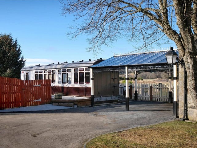 A restored carriage built at the Inverurie works in 1916 stands behind the platform to the side of the property.
