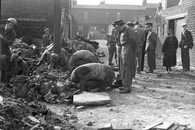 Locals examine the wheels of a German bomber which crashed in a back lane in Sunderland.