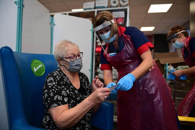 A nurse prepares to administer the Pfizer-BioNTech COVID-19 vaccine to patient Trixie Walker at the Northern General Hospital in Sheffield (Photo by Andy Stenning / POOL / AFP) (Photo by ANDY STENNING/POOL/AFP via Getty Images)