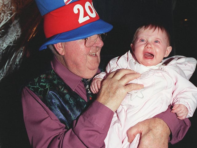 Old and young residents hail the new year at Sycamore Grove, Cantley, Doncaster at their Millennium street party. Pictured are John Custons (78) and Emily Stacey (6 months)
