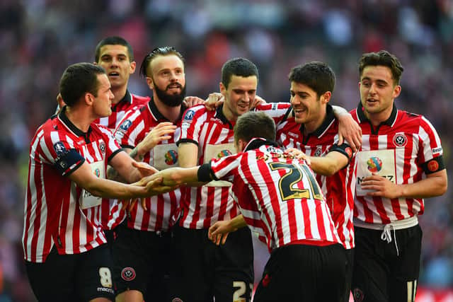 Stefan Scougall of Sheffield United is mobbed by his team mates after putting United ahead again against Hull in the 2014 FA Cup semi-final at Wembley  (Photo by Shaun Botterill/Getty Images)