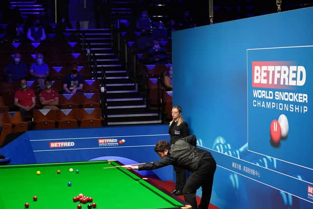 Yan Bingtao of China plays a shot during the 2021 Betfred World Snooker Championship (photo by Zac Goodwin - Pool / Getty Images).