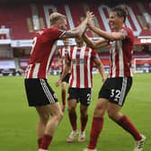 Sheffield United's Oliver McBurnie, left, celebrates with Sander Berge his side's third goal during the English Premier League soccer match between Sheffield United and Tottenham Hotspur at Bramall Lane in Sheffield, England, Thursday, July 2, 2020. (Oli Scarff/Pool via AP)