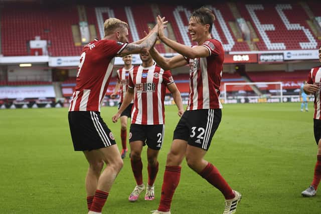 Sheffield United's Oliver McBurnie, left, celebrates with Sander Berge his side's third goal during the English Premier League soccer match between Sheffield United and Tottenham Hotspur at Bramall Lane in Sheffield, England, Thursday, July 2, 2020. (Oli Scarff/Pool via AP)