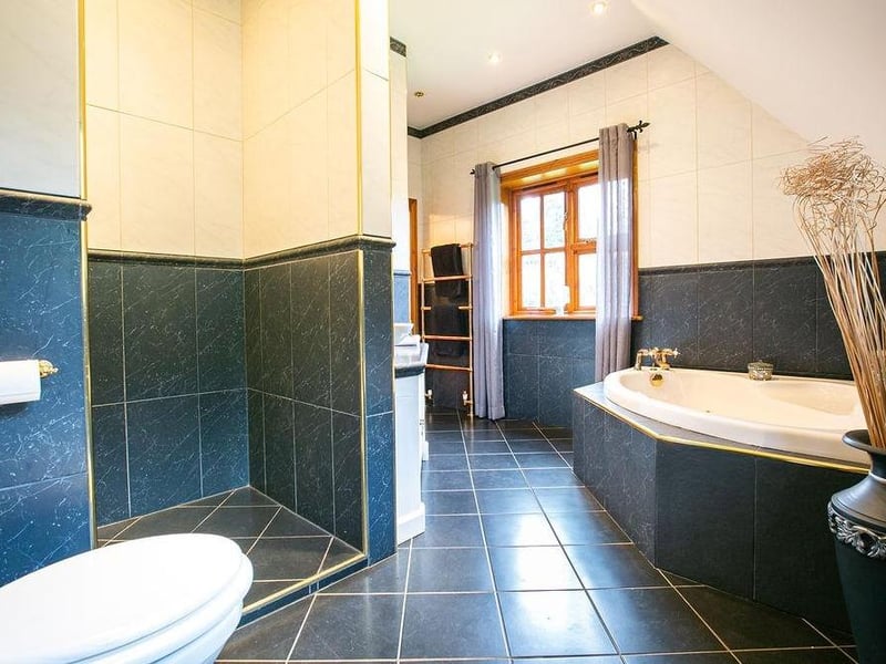 An impressive, large en-suite bathroom to the main bedroom. It has a raised spa bath, walk-in shower and a design that can only be appreciated in person.