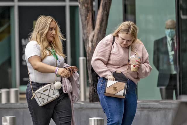 Family and friends of the Manchester bomb victims arrive at the Hilton Hotel in Manchester to watch the sentencing of Hashem Abedi via videolink, one woman (left) wears a pink Chloe and Liam wristband in support of victims, Chloe Rutherford and Liam Curry.