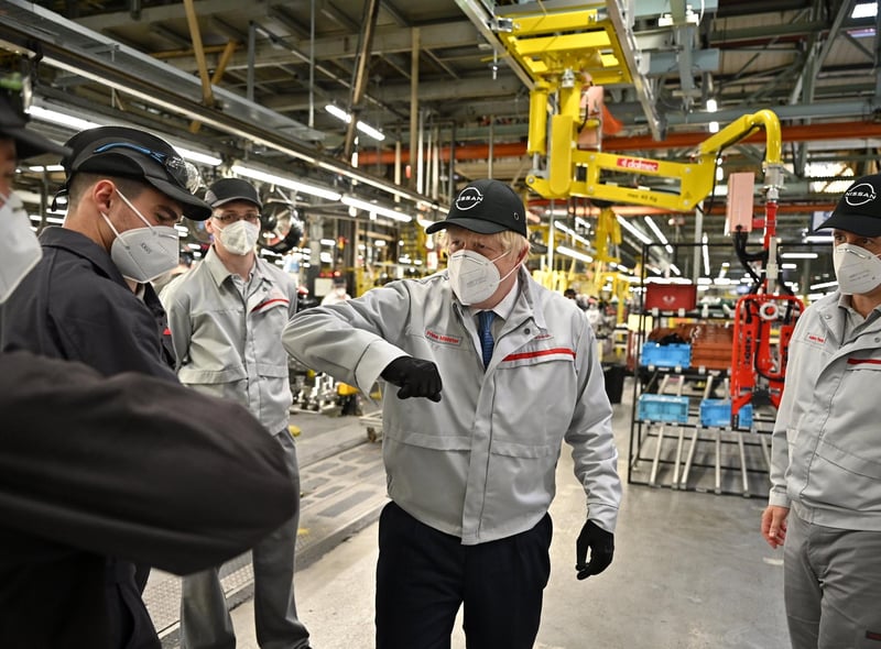 Mr Johnson elbow bumps some staff at the Nissan plant. Picture: Jeff J Mitchell/Getty Images.