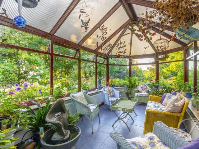 The conservatory is a blaze of colour. Complete with central-heating radiators and surrounding windows.