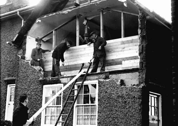 Our picture shows workmen boarding up the front of a house in Crookes after the gales had blown out the complete bedroom wall at the front of the house in February 1962