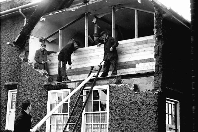 Our picture shows workmen boarding up the front of a house in Crookes after the gales had blown out the complete bedroom wall at the front of the house in February 1962