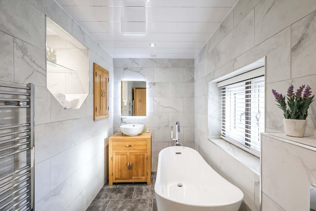The stand alone bath, smart tiling and chrome towel rail give this a contemporary feel.