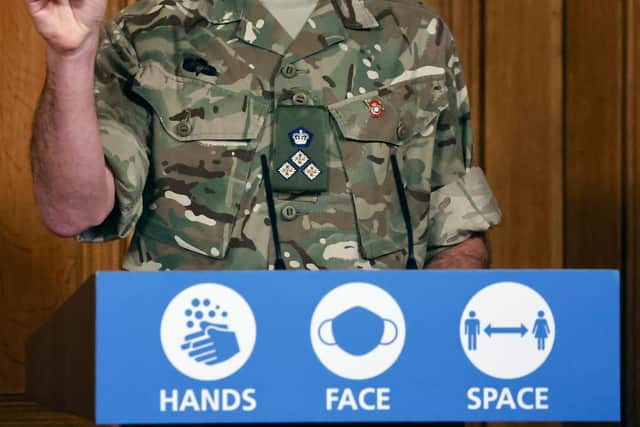 British Army Brigadier, Joe Fossey, who is coordinating the mass coronavirus testing pilot in Liverpool, holds up the components of a lateral flow Covid-19 test at a Downing Street press conference.