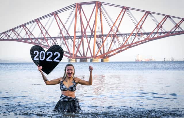 Joda Quigley, from Falkirk takes part in a New Year's Day dip in front of the Forth Bridge at South Queensferry, Edinburgh. Covid restrictions across Scotland have meant that many new year traditions including the official annual Loony Dook have been cancelled. Picture date: Saturday January 1, 2022. PA Photo. Photo credit: Jane Barlow/PA Wire