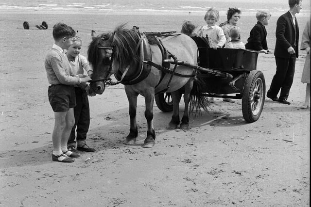Children enjoy rides on Portobello beach, outside Edinburgh, in September 1965