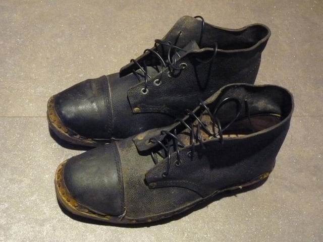 A pair of steel toe cap boots found under some rubbish in a locker room. 
There is no wear at all on the soles and the wooden section suggests these are very old clogs