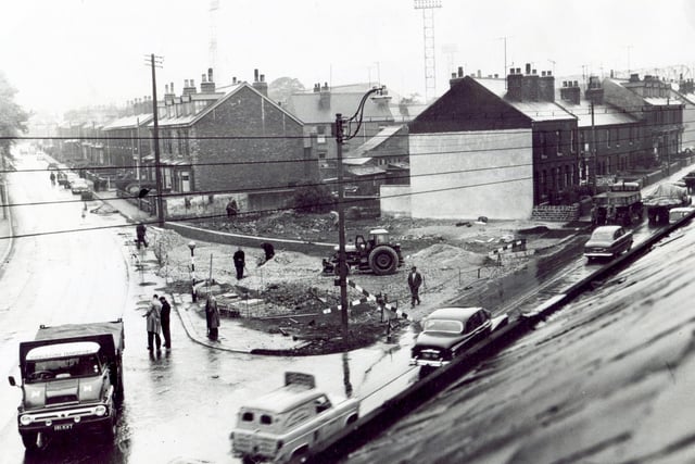 A roof top view of the developments at the corner of Penistone Road and Parkside Road where the corner has been removed.  In the background are the lighting towers of Sheffield Wednesday's football ground, June 1, 1961