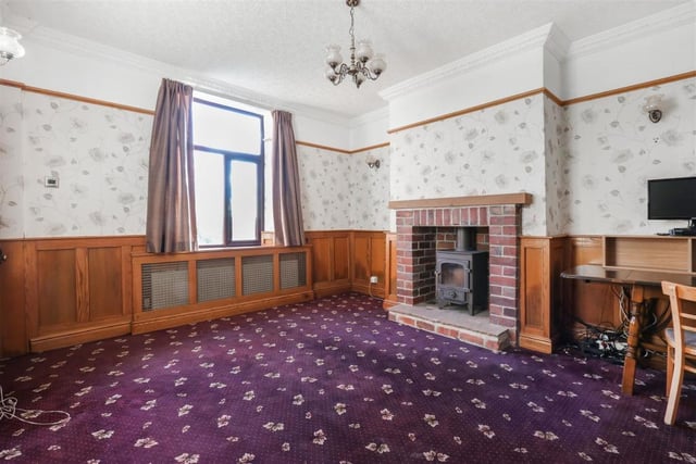 Spacious room with a stove surrounded by a brick fireplace.
