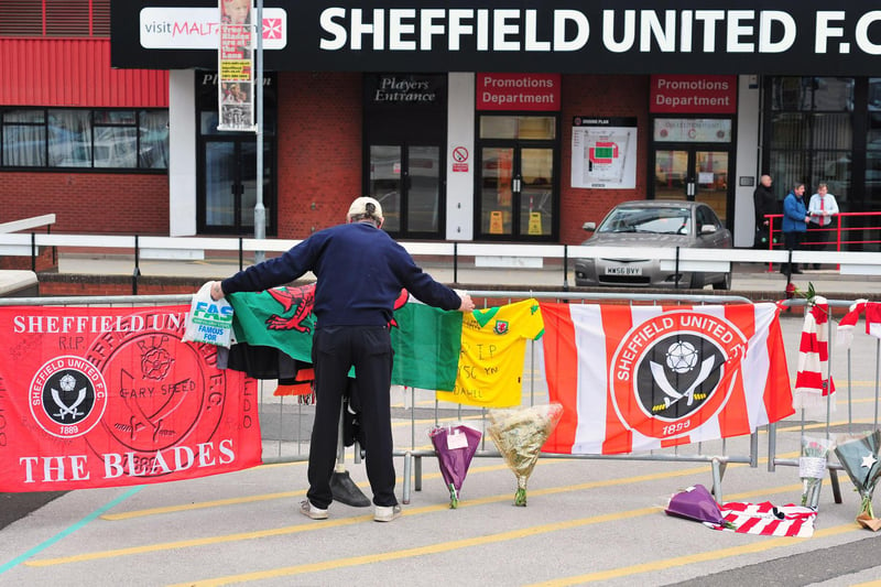 A Unitedite lays a Welsh flag outside Bramall Lane in tribute to former player and manager Gary Speed