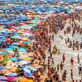 People sunbathe at Levante Beach (Photo by David Ramos/Getty Images)