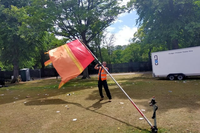A worker removes flags on the main festival field