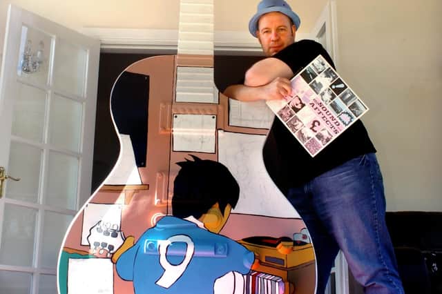 Pete McKee painting a 10ft guitar for rock star Noel Gallagher in April 2007